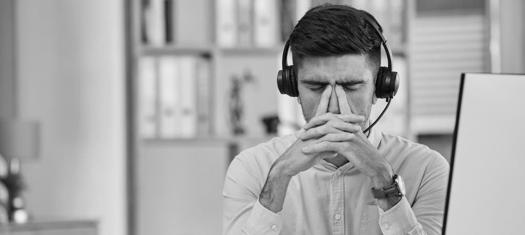 A man in front of his computer realizing he suffered a cyber attack.