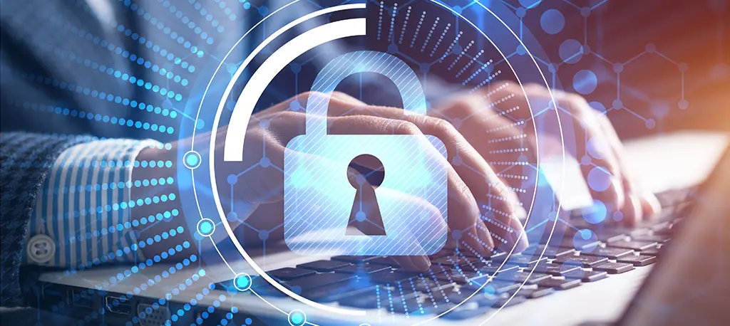 A padlock over a person typing on their laptop, symbolizing cybersecurity.