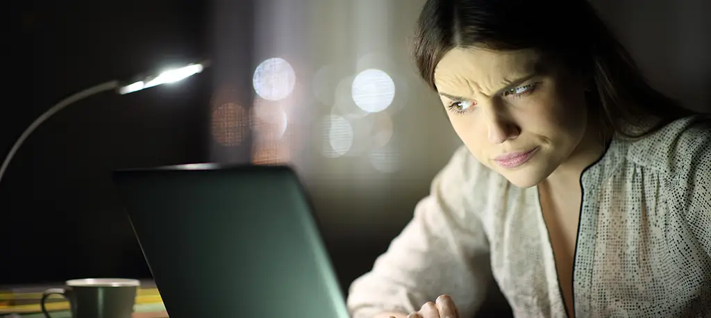 Woman looking at a computer screen with a suspicious look.