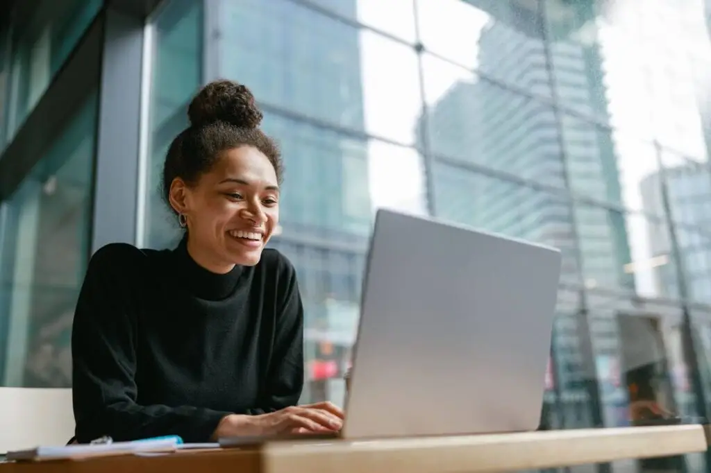 A smiling young woman using her laptop