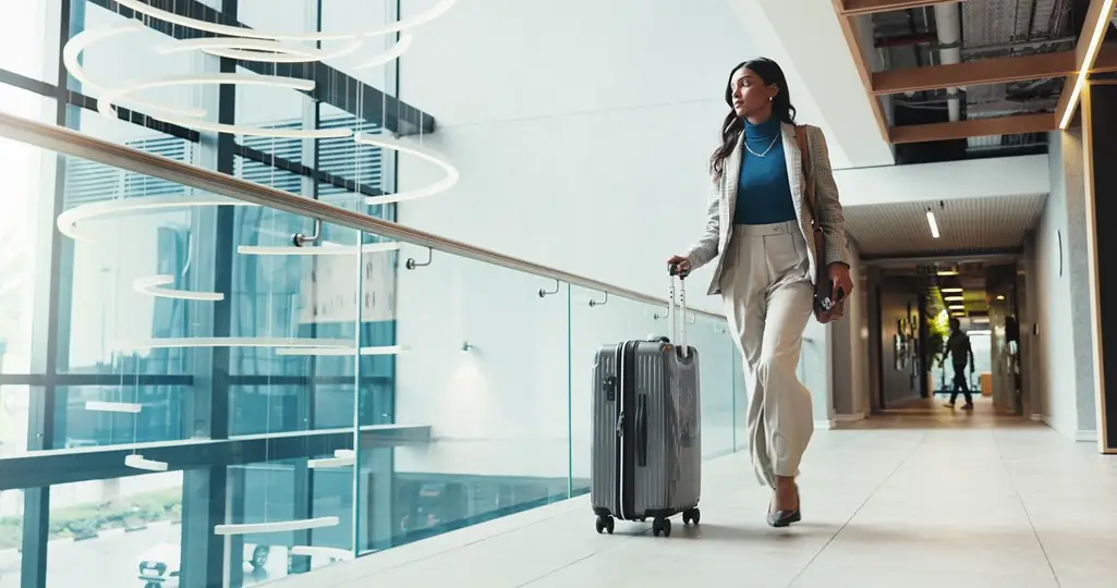 A female executive on a business trip, walking with a suitcase